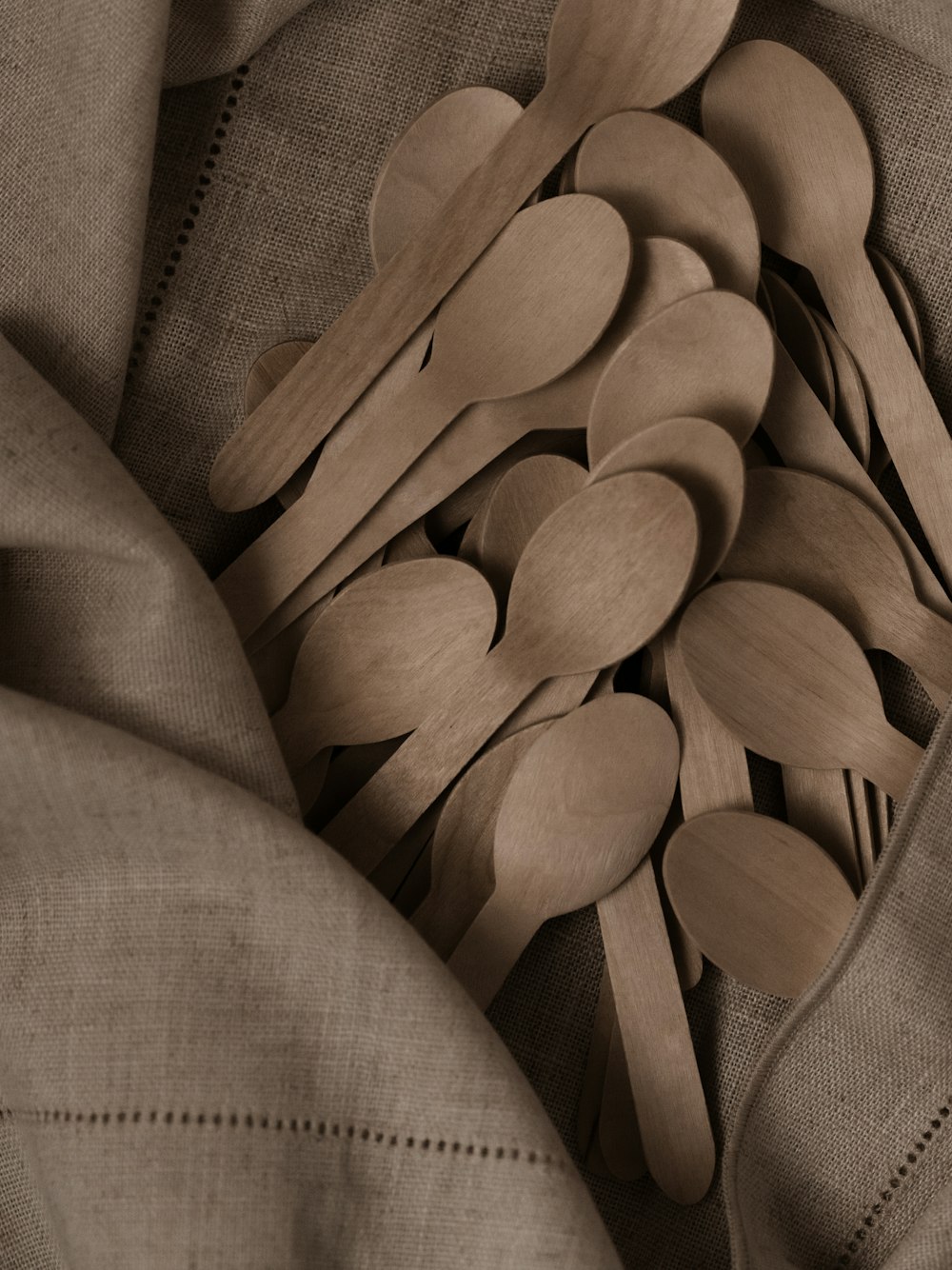 a pile of wooden spoons sitting on top of a cloth