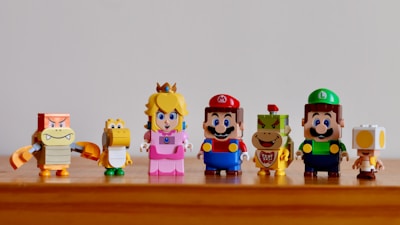a group of nintendo figurines sitting on top of a wooden table