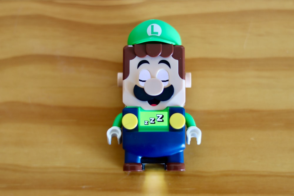 a toy figure of a man with a green hat
