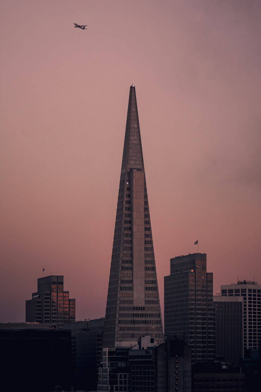 a plane flying over a city at sunset