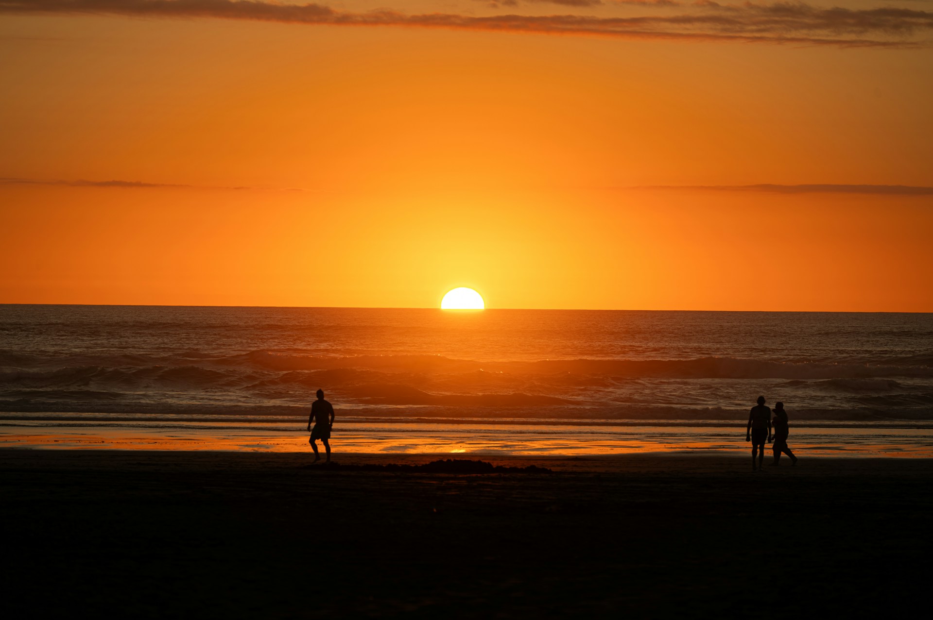 a couple of people standing on top of a beach