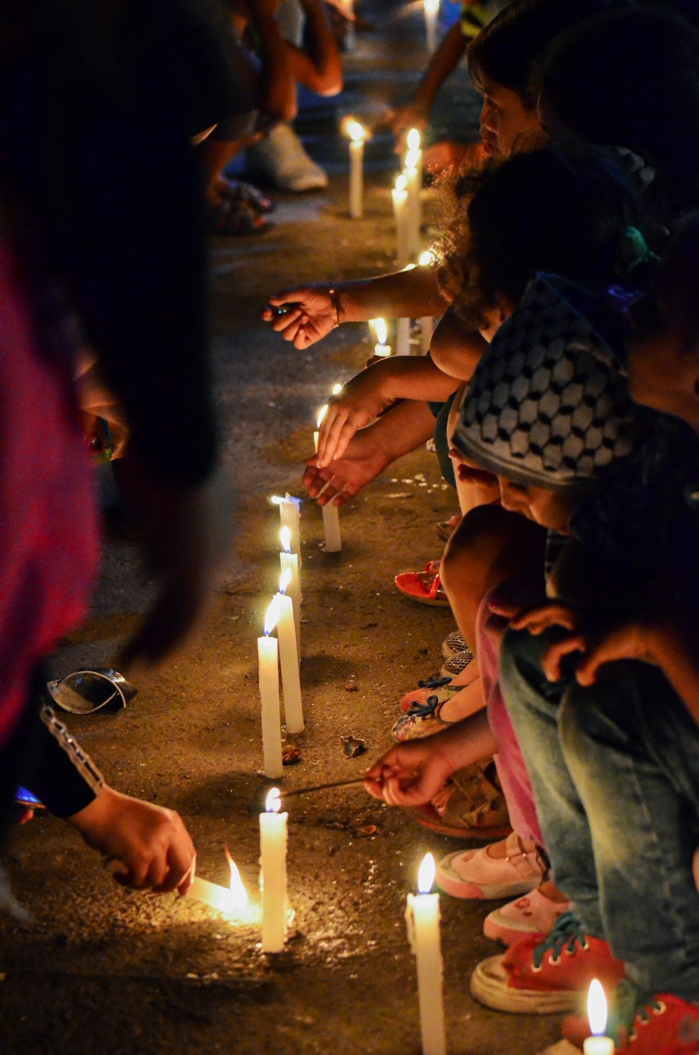 a group of people kneeling down to light candles