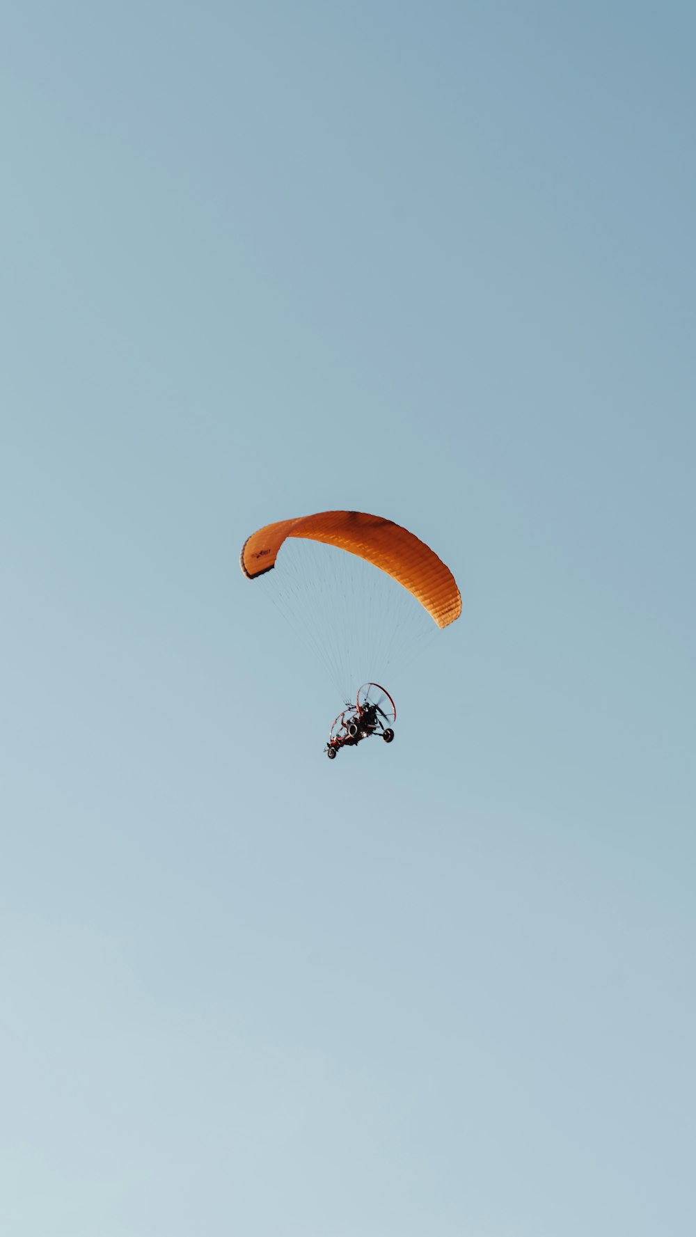 a person is parasailing in the blue sky