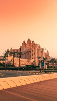 a large building with a lot of palm trees in front of it