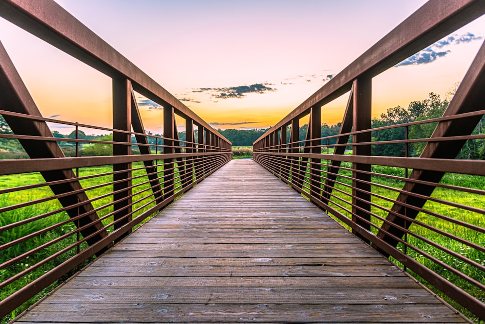 a wooden bridge with a sunset in the background