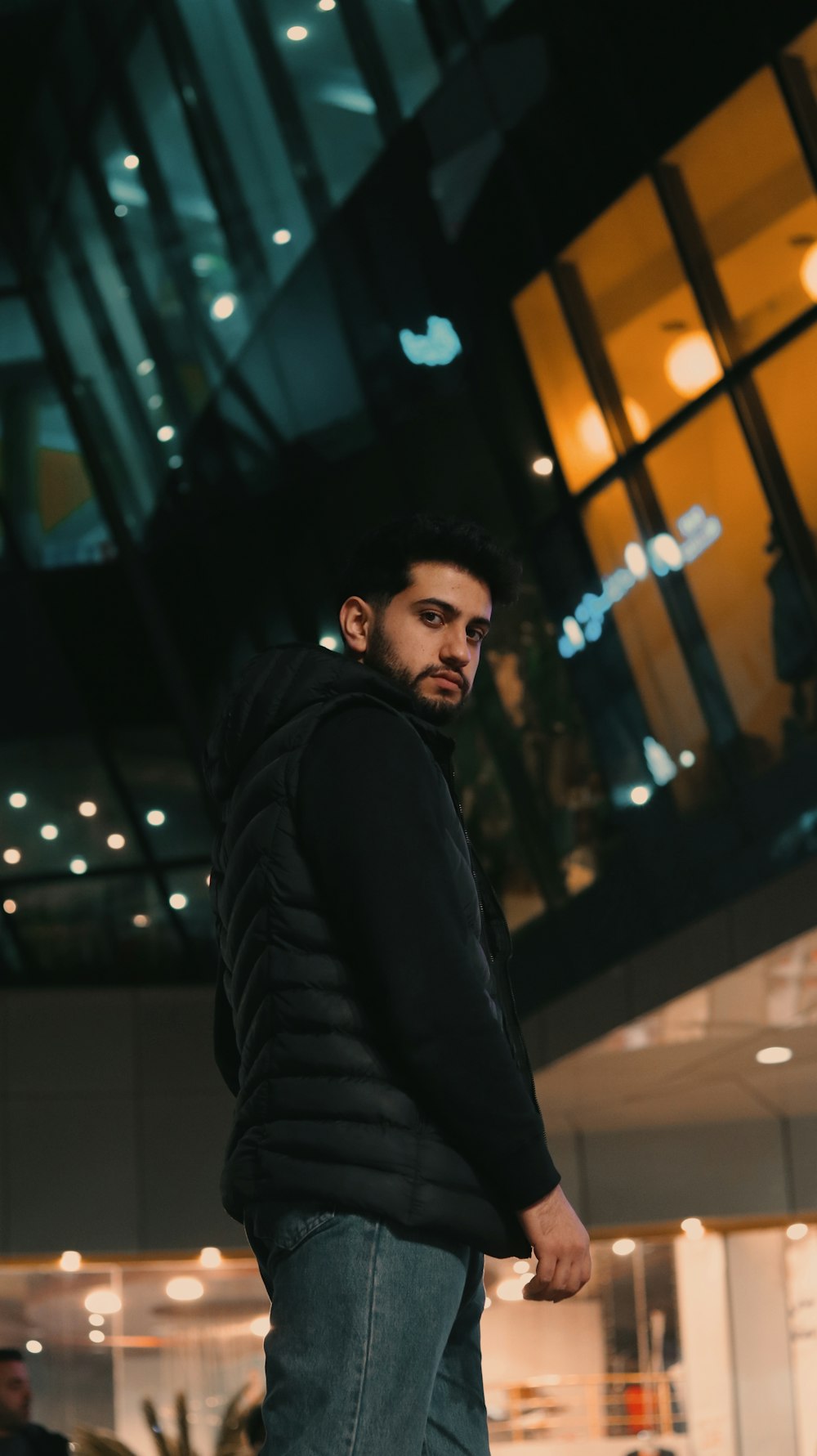 a man standing in front of a building at night