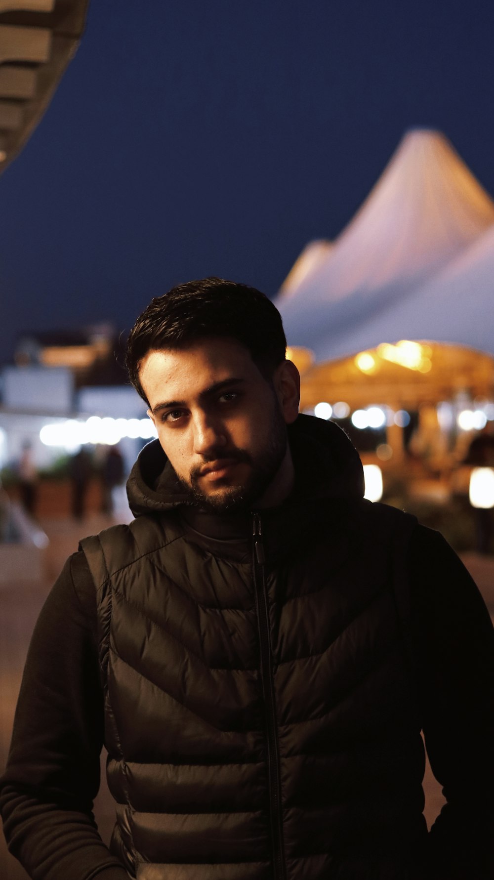 a man standing in front of a building at night