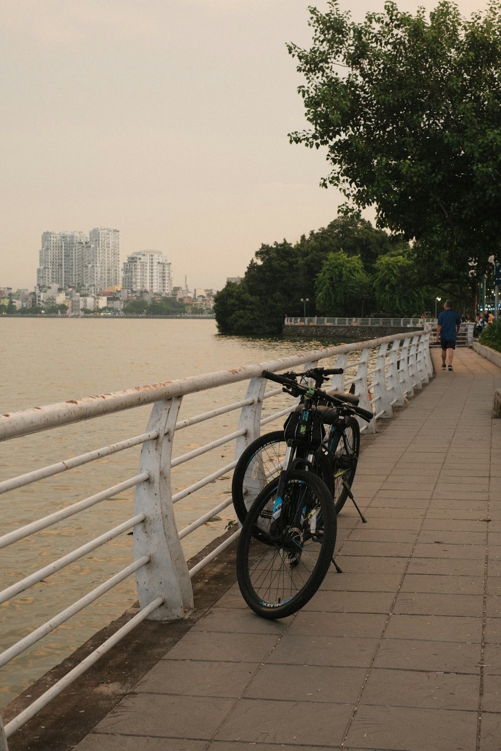 a bicycle parked on a bridge next to a body of water