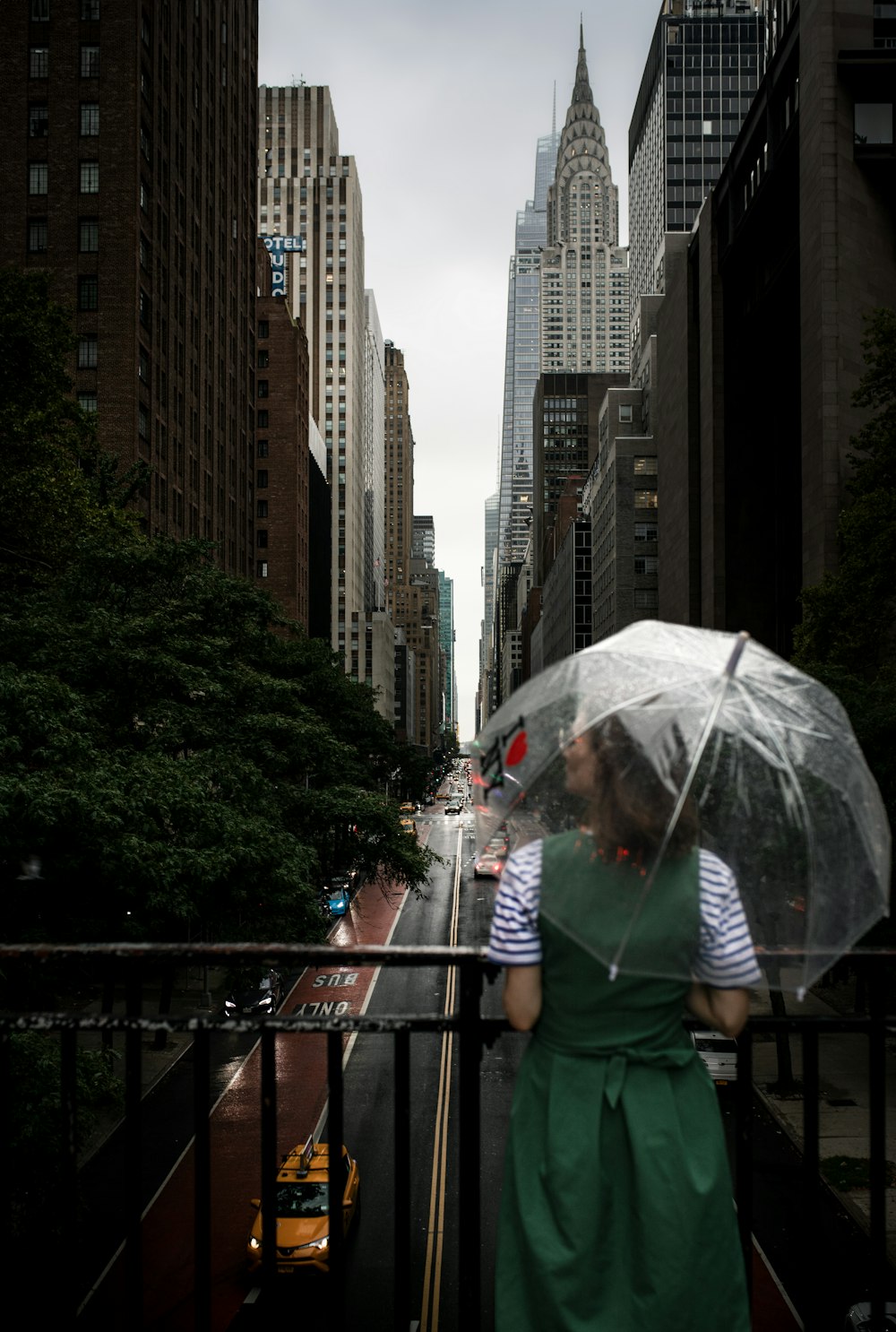 uma mulher em um vestido verde segurando um guarda-chuva