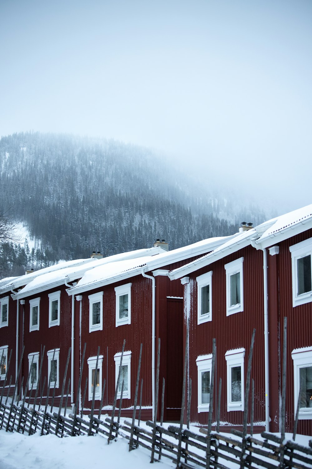 a row of red houses with a mountain in the background