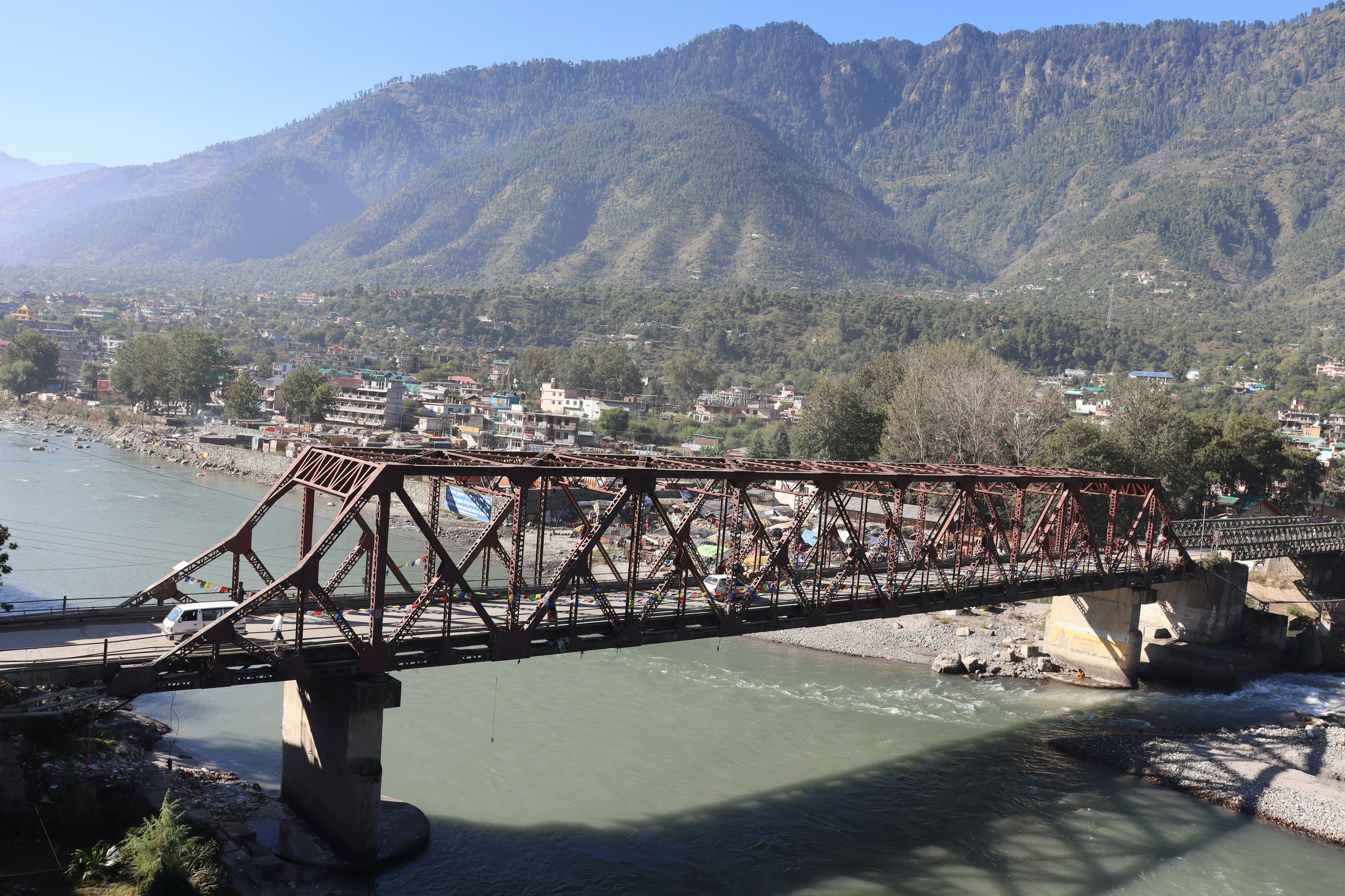 a bridge over a body of water with mountains in the background