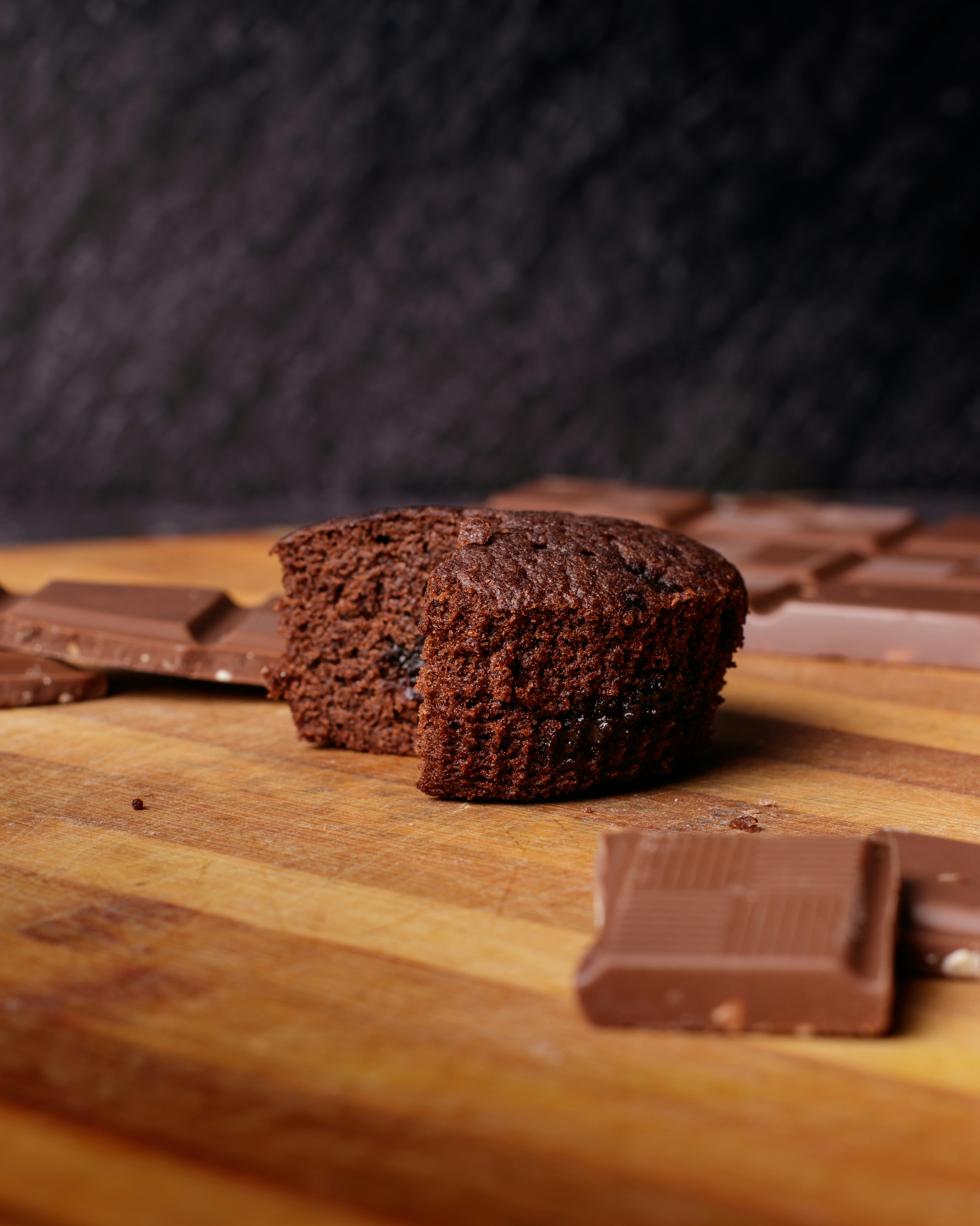a piece of chocolate cake sitting on top of a wooden cutting board