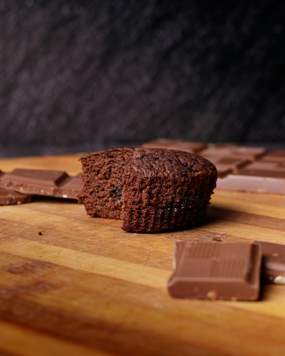 a piece of chocolate cake sitting on top of a wooden cutting board