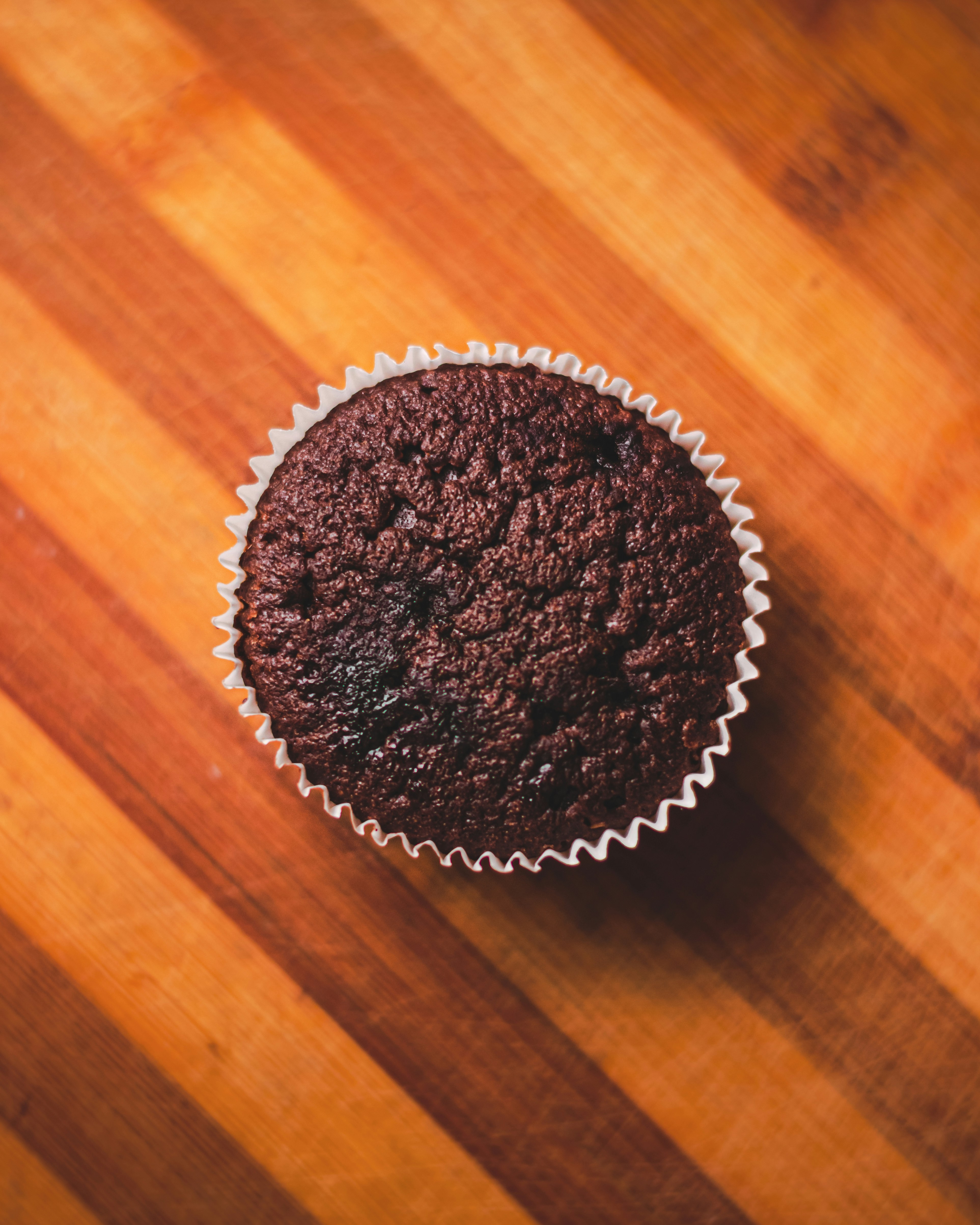 a chocolate cupcake sitting on top of a wooden table