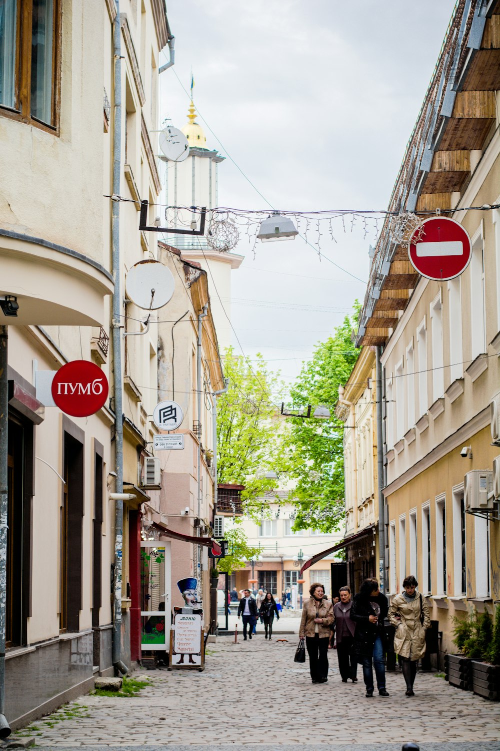 a group of people walking down a cobblestone street