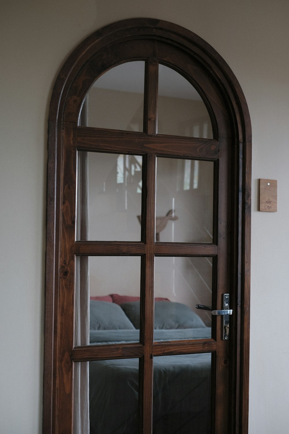 a bedroom with a bed and a large arched window