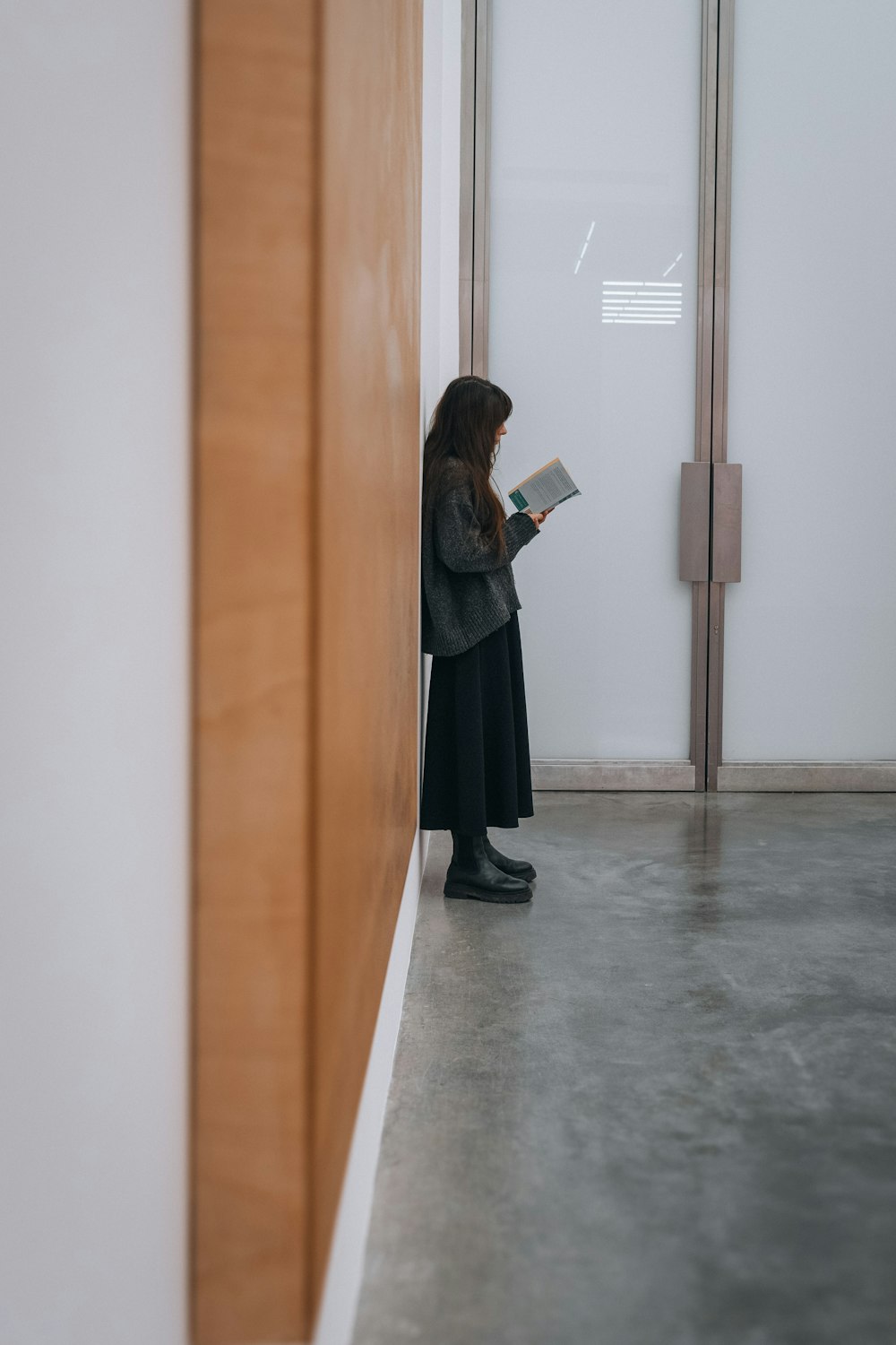 a woman standing in a room reading a book