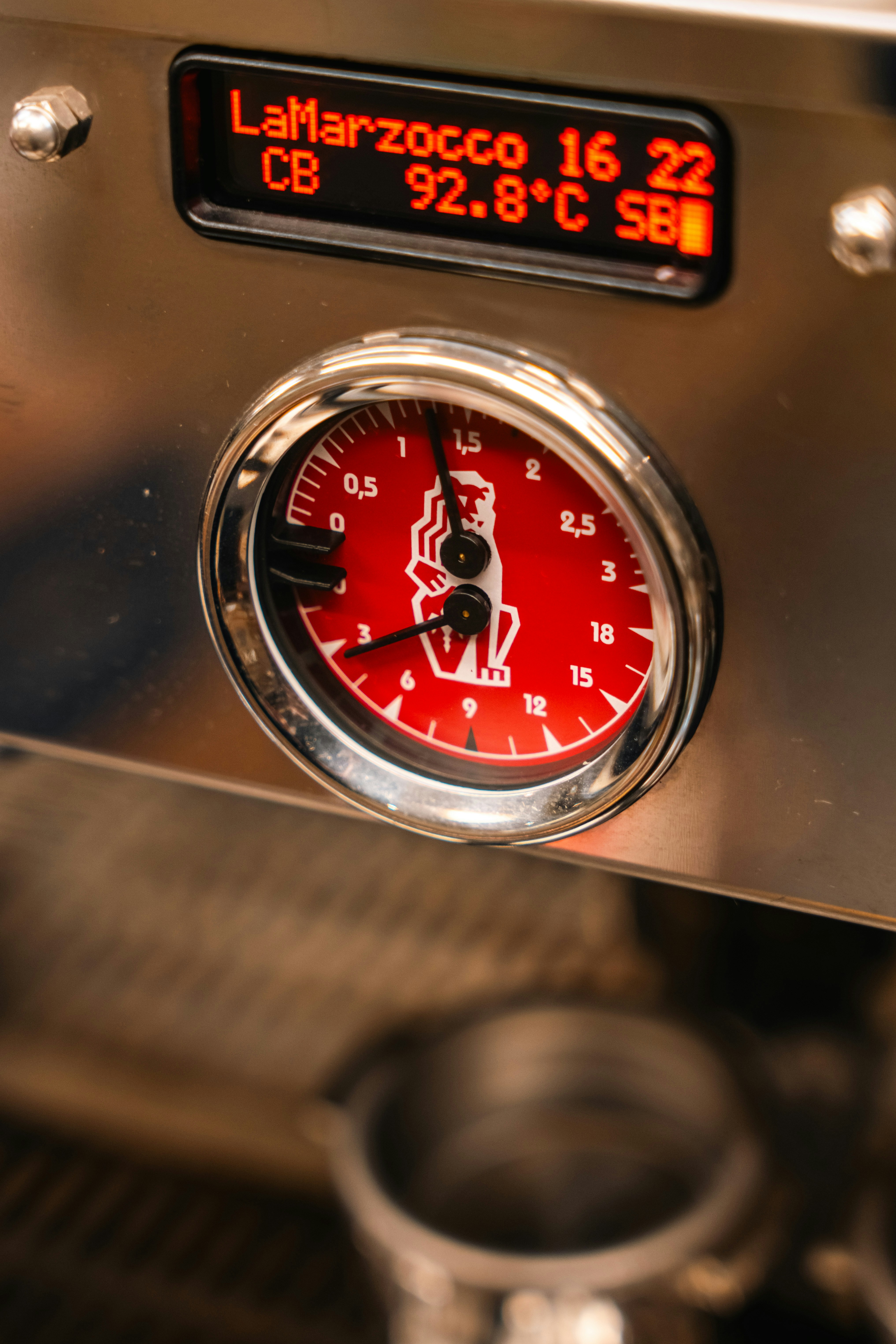 Primo piano di una macchina da espresso con manometri di pressione e temperatura