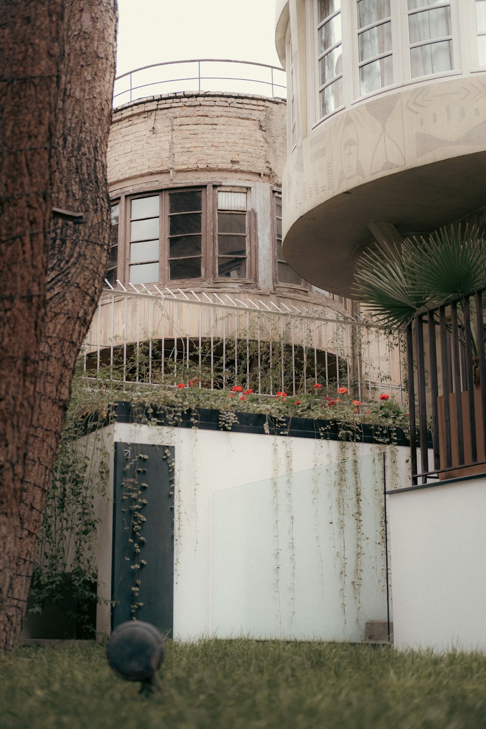 a building with a balcony next to a tree