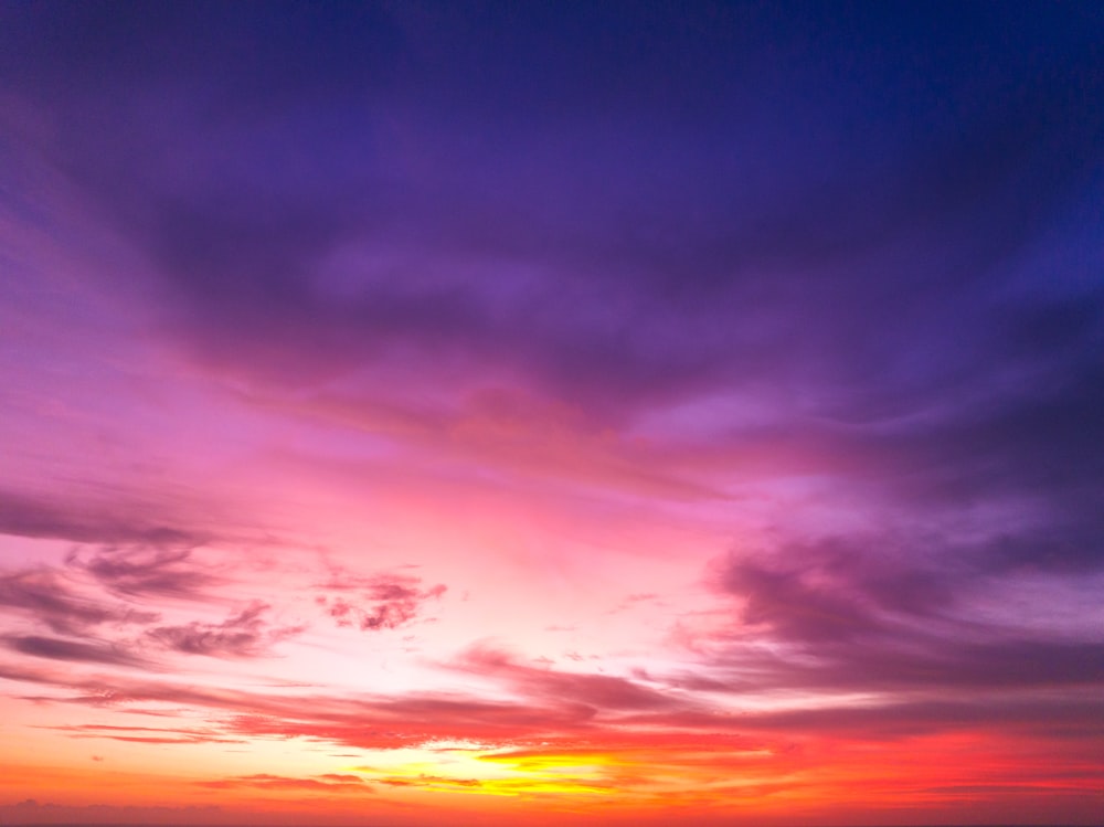 a beautiful sunset over the ocean with a boat in the water