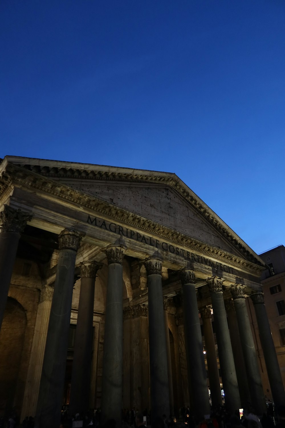 a very tall building with many columns and a sky background