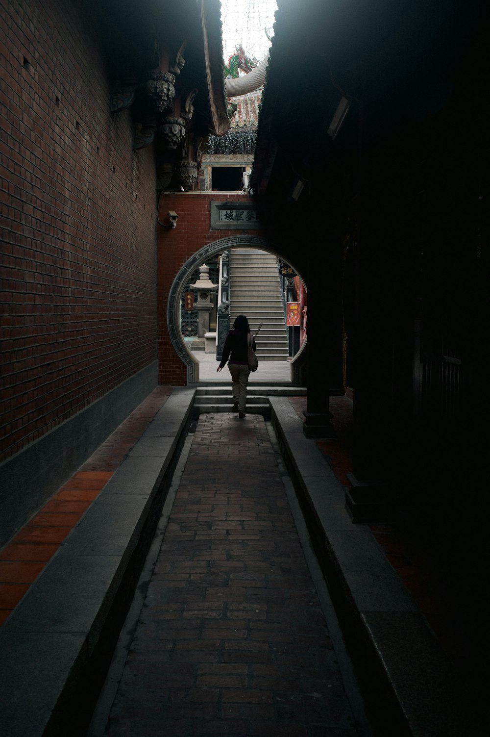 a person walking down a dark alley way