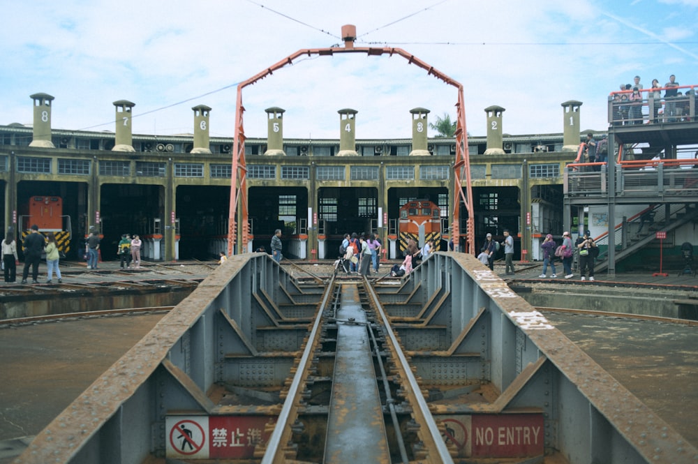 a group of people standing on top of a train track