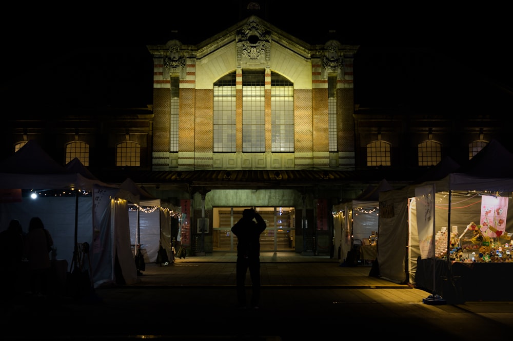 a man standing in front of a building at night