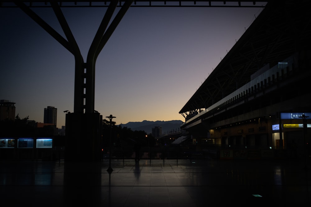 a silhouette of a person standing in front of a train station