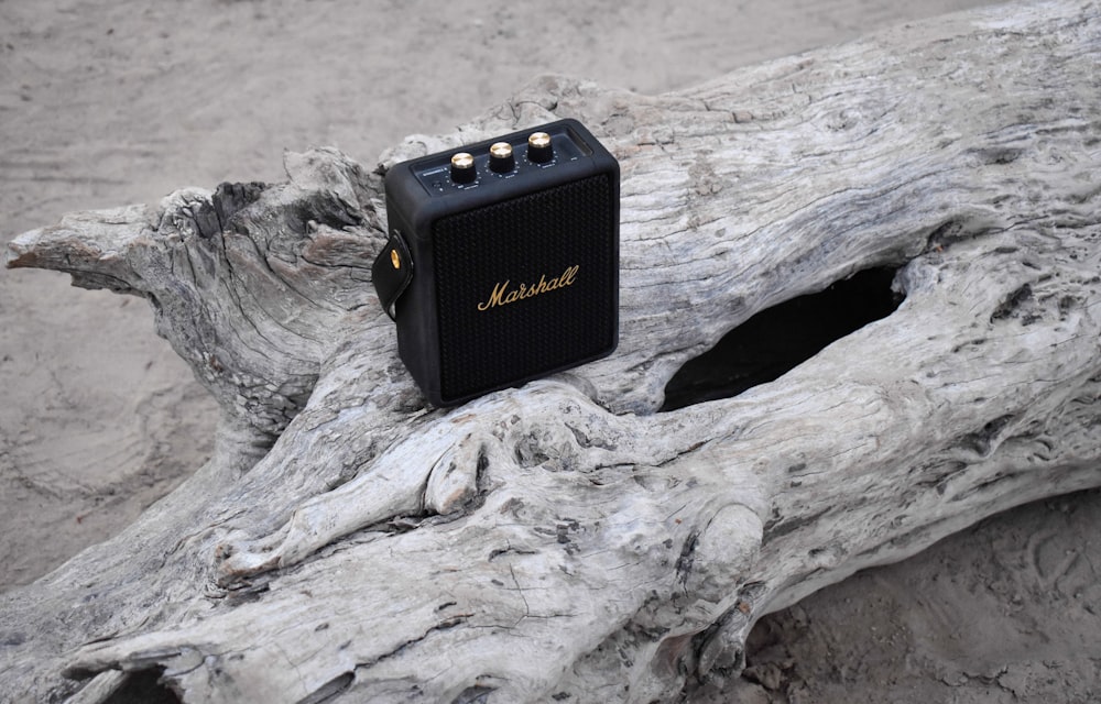 an old radio sitting on a piece of driftwood