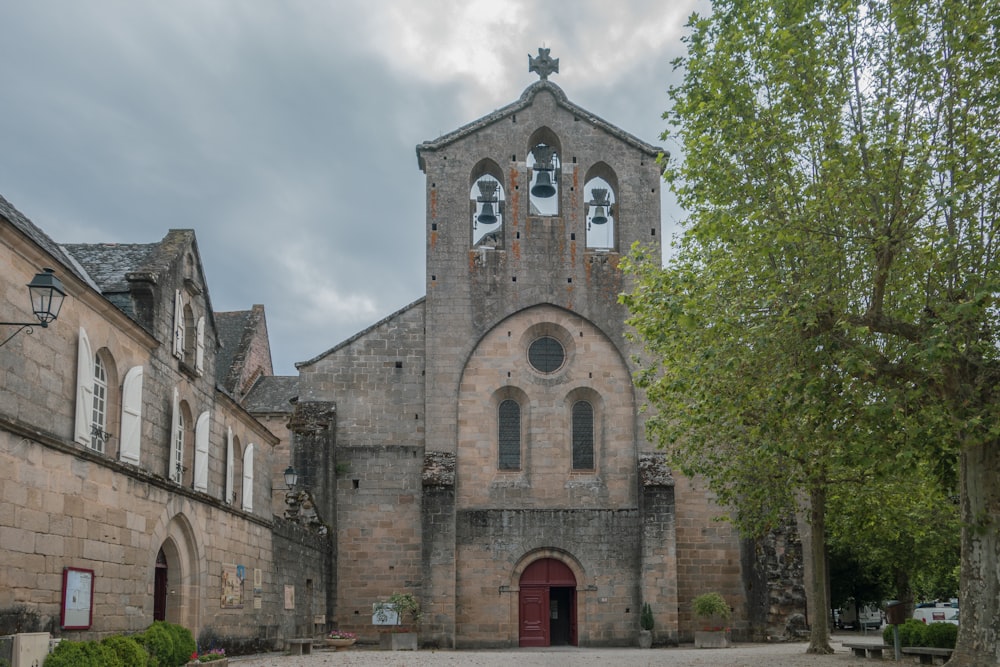 an old church with a tree in front of it