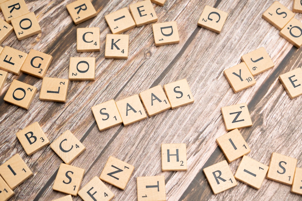 Scrabble-Fliesen zum Buchstabieren von Wörtern auf einer Holzoberfläche