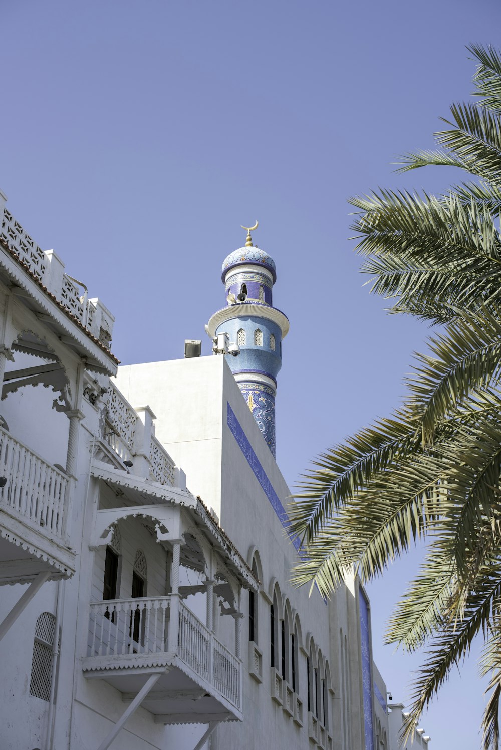 a tall white building with a blue and yellow tower