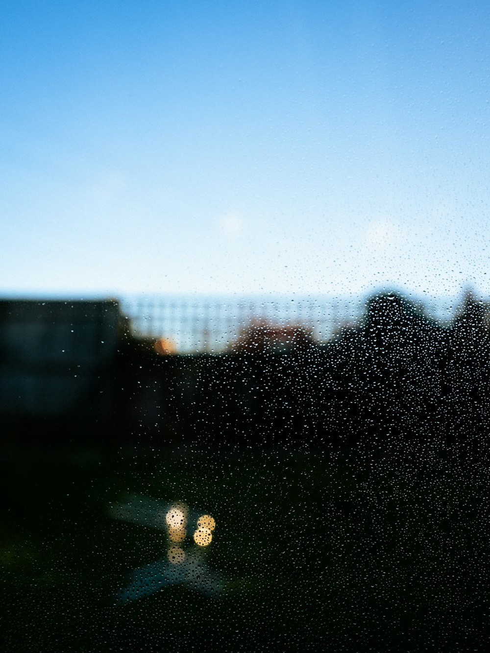 a window with rain drops on it and a building in the background