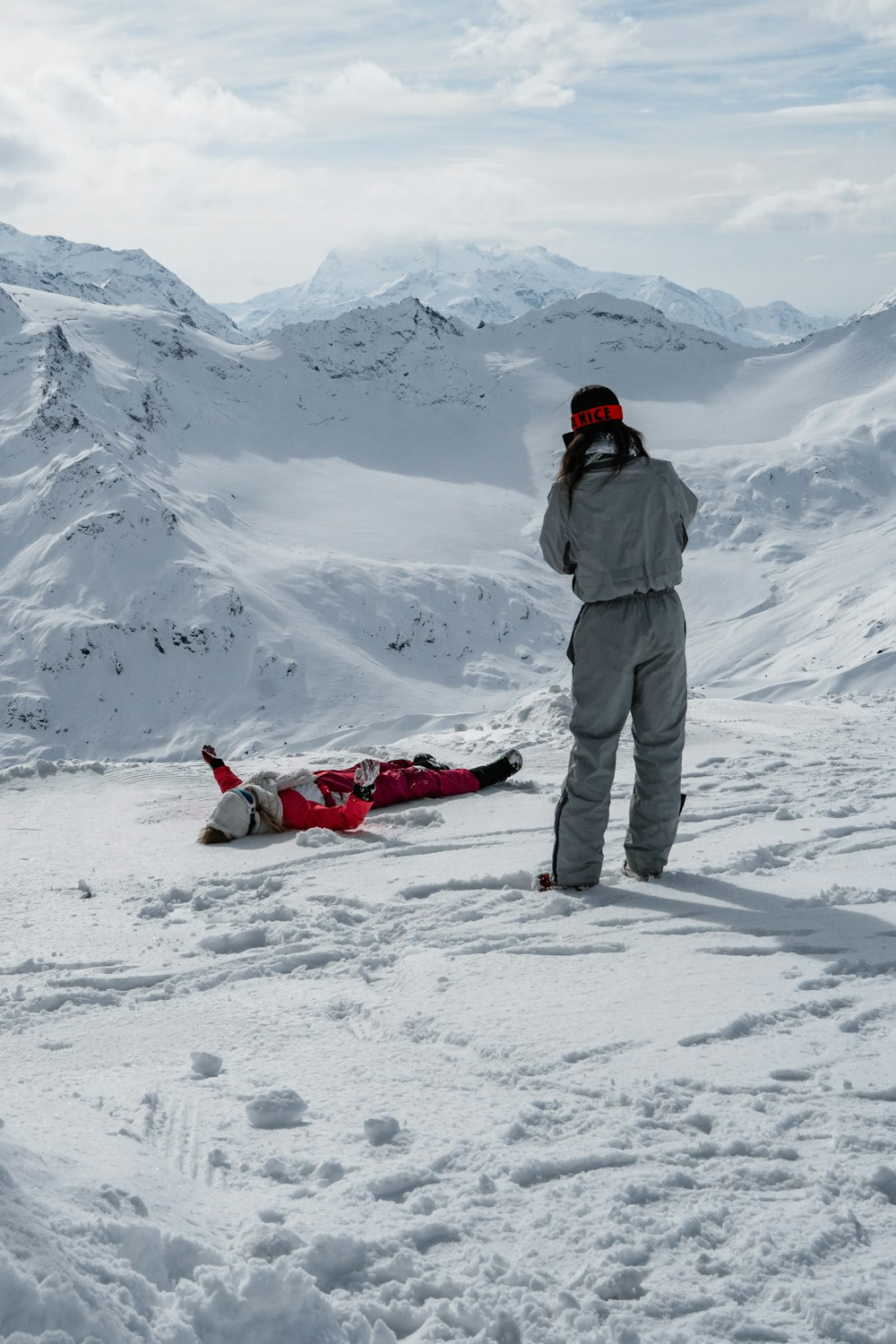 a man standing next to a woman on top of a snow covered slope