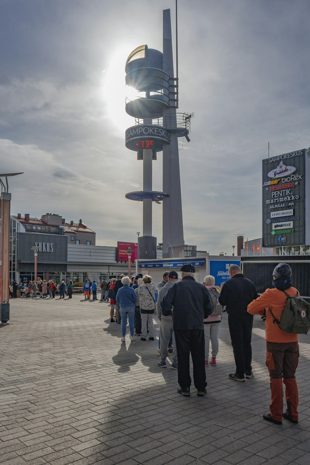 a group of people standing around a tall tower