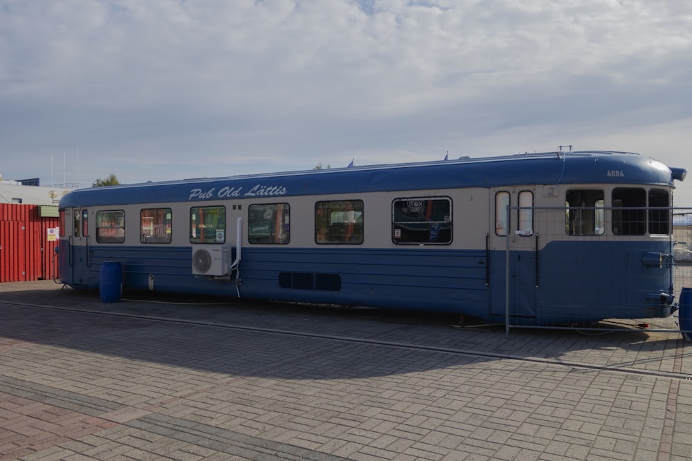 a blue and white bus parked on the side of the road