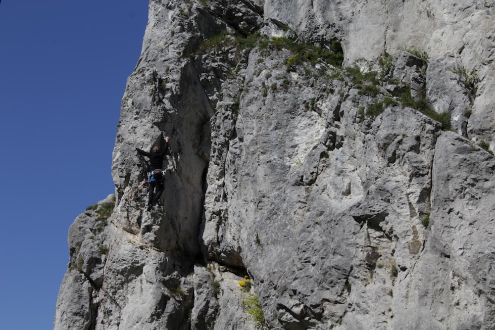 a man climbing up the side of a mountain