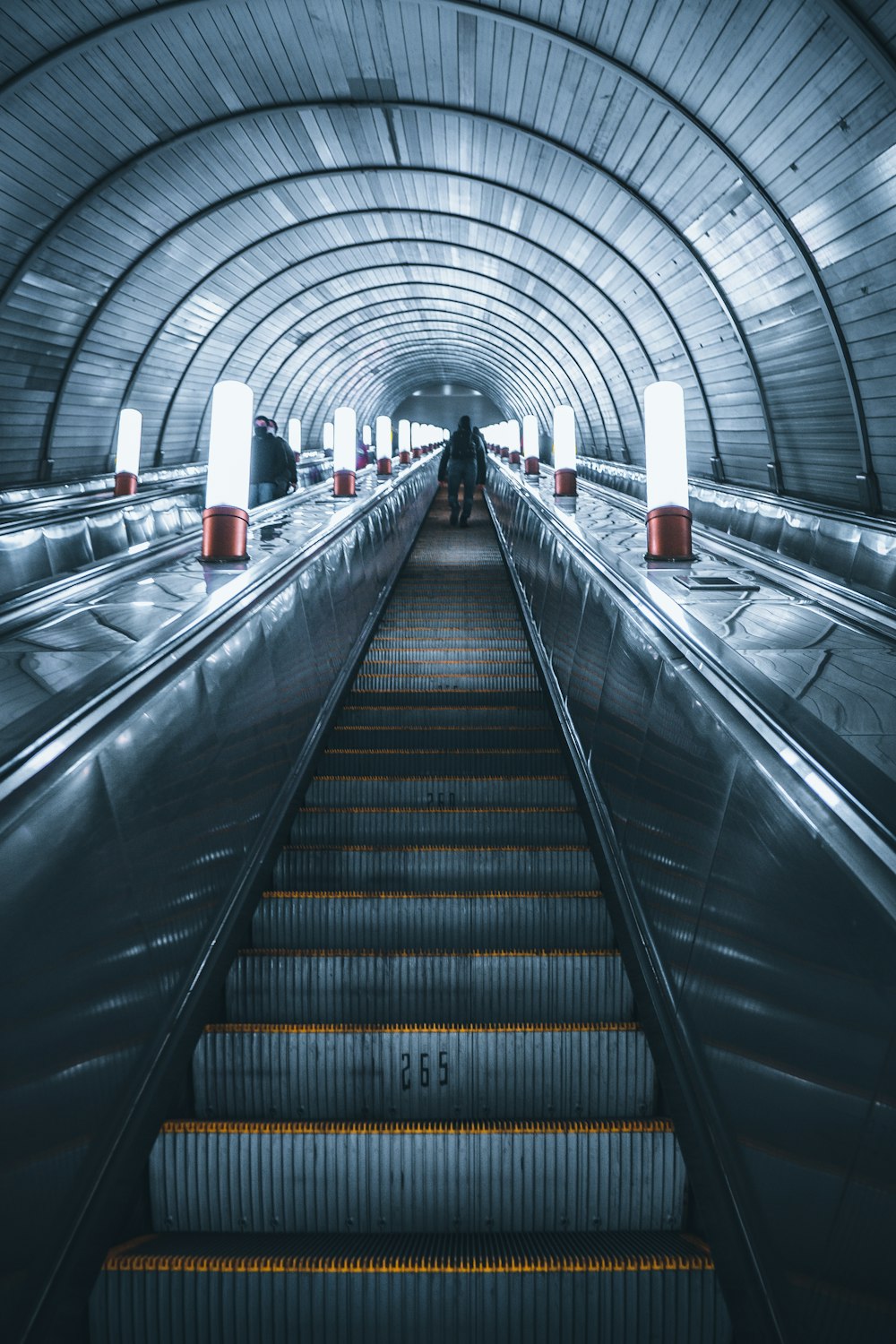 eine Rolltreppe in einer U-Bahn-Station, auf der Menschen entlang gehen