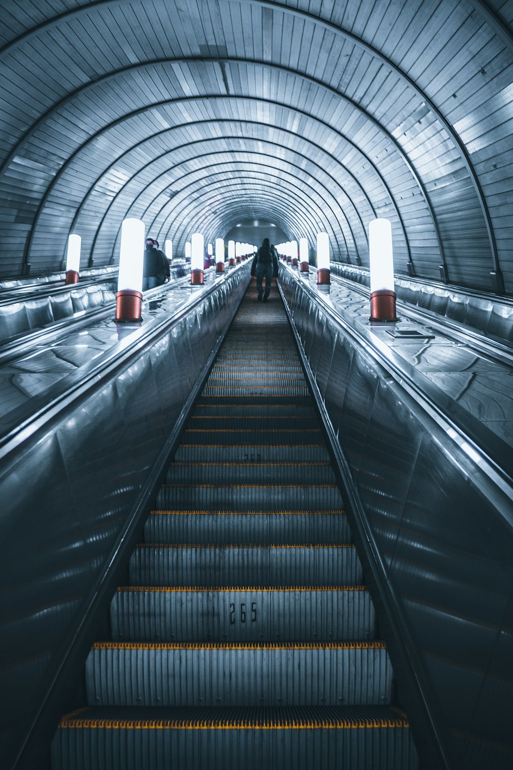 an escalator in a subway station with people walking down it