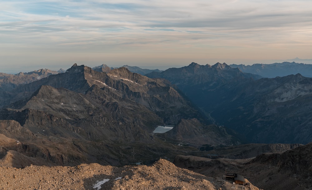 a view of a mountain range with a bench in the foreground