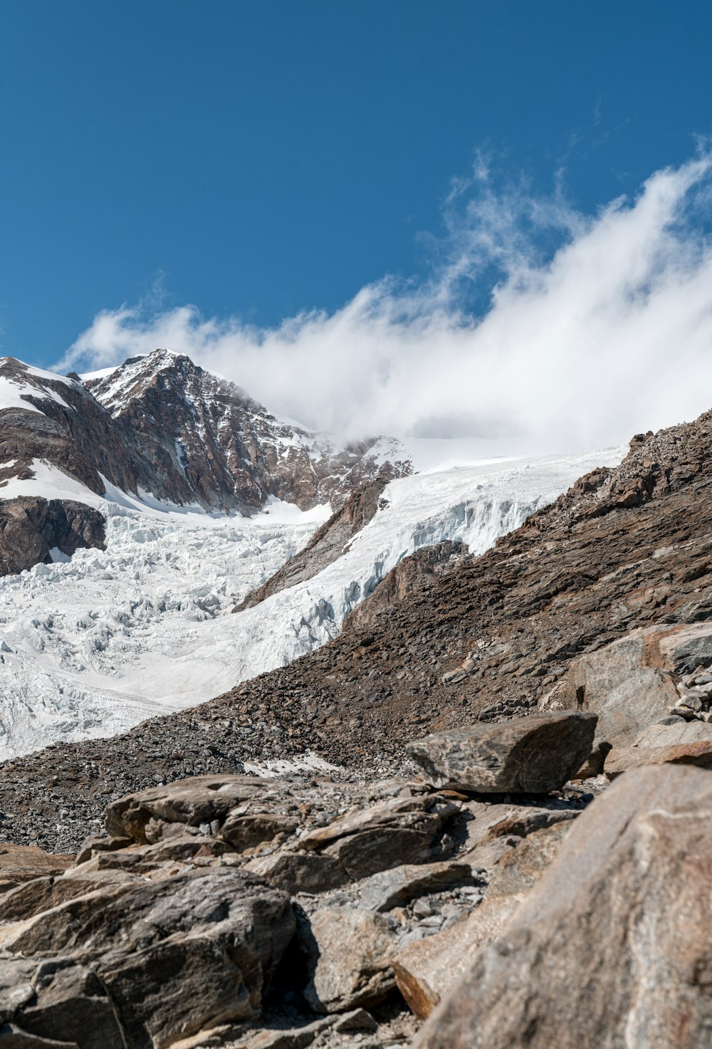 a rocky mountain with a glacier in the background