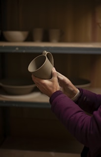 a woman is holding a vase in her hands