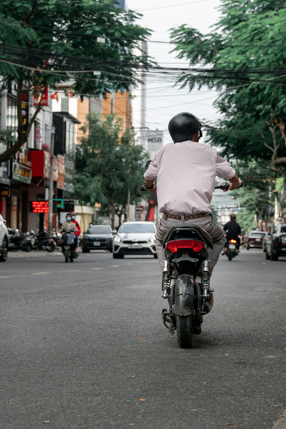 a man riding a motorcycle down a street