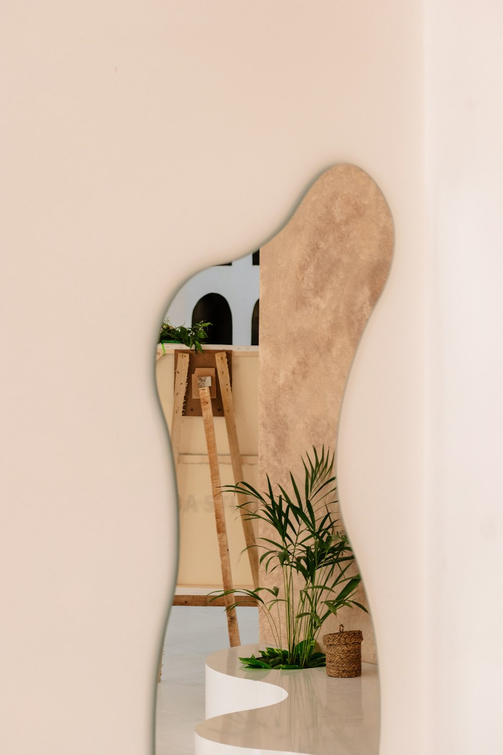 a mirror reflecting a room with a ladder