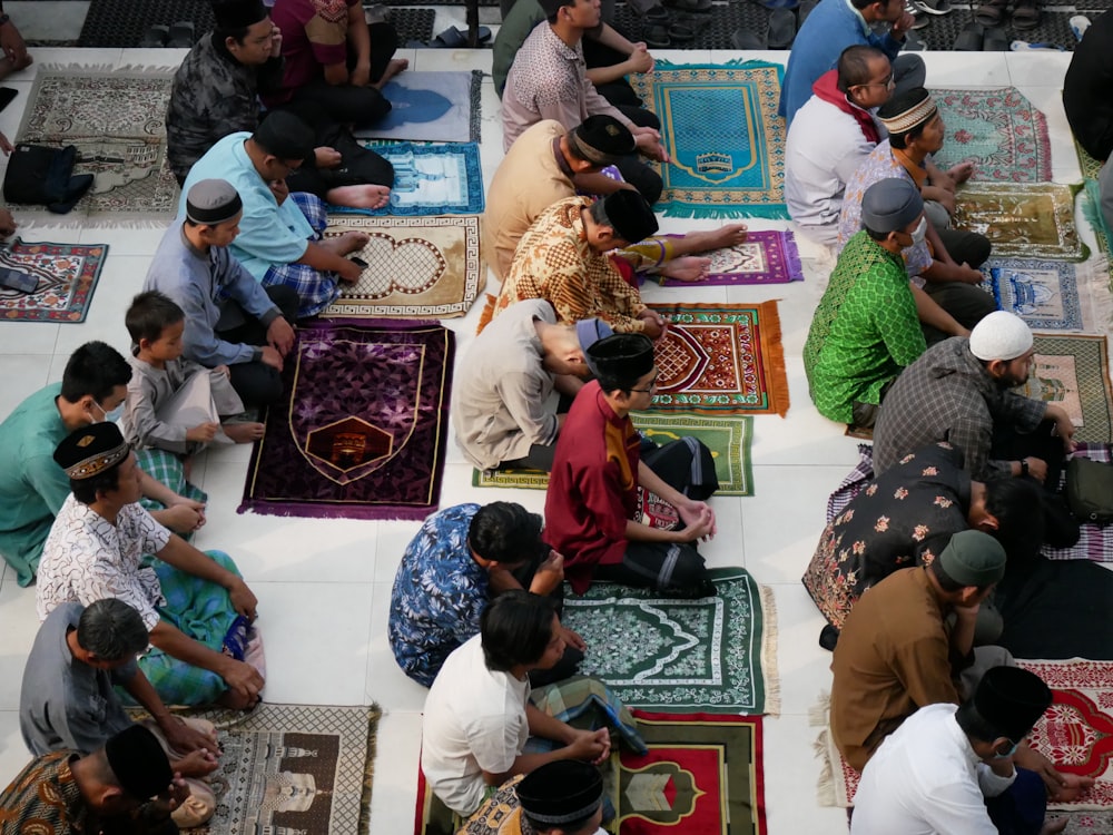 a group of people sitting on top of rugs