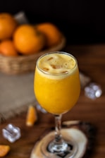 a glass of orange juice sitting on top of a table
