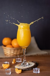 a glass of orange juice on a wooden table