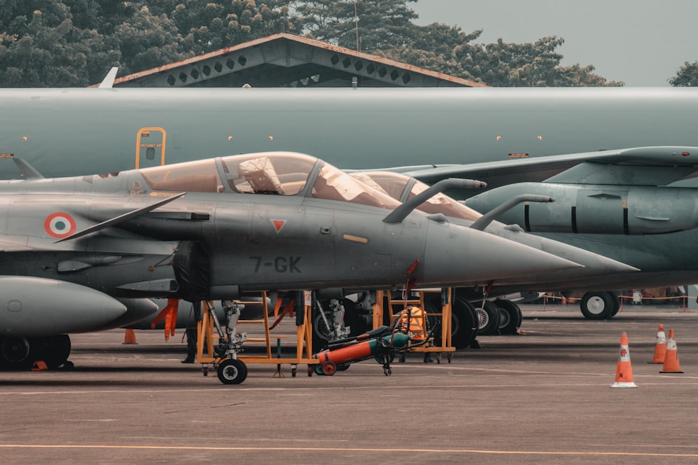 a fighter jet sitting on top of an airport tarmac