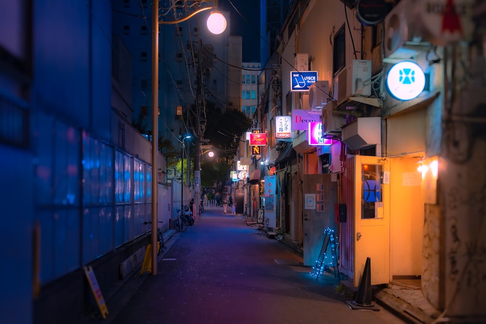 a city street at night with neon signs